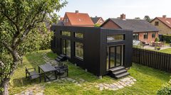 Visualisering: Shakespeare sommerhus i træ som modulhus med sauna – sort facade i en dansk have