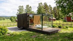 Visualisering: Vivaldi modulhus i træ med facade af brændt træ i en sommerhave